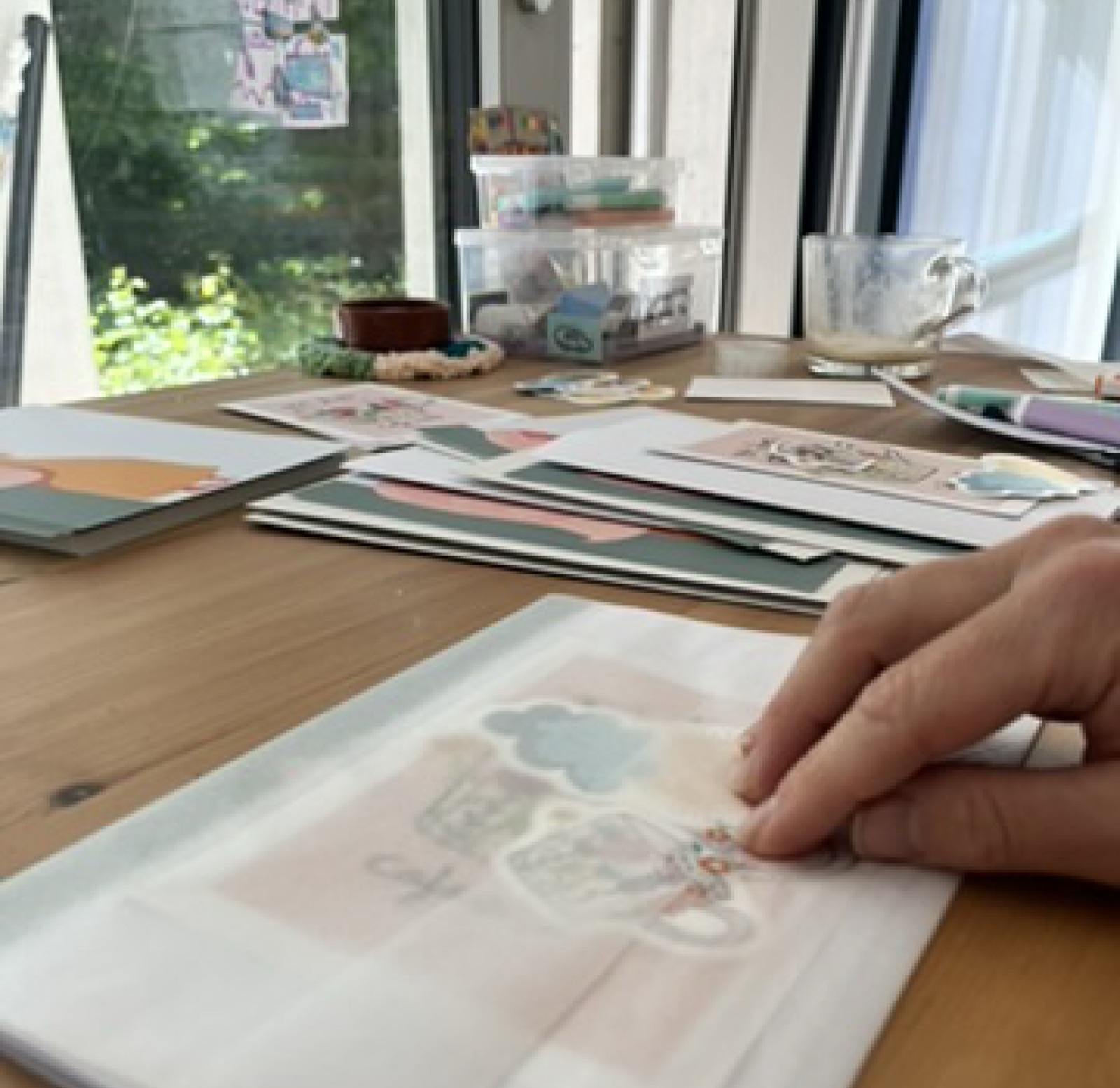 Camila’s hand placing art onto an envelope